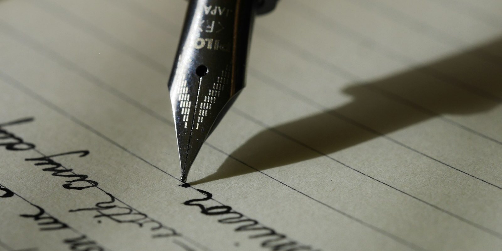 Pluma estilográfica escribiendo en cuaderno, símbolo de reflexión, autonomía y creencias profesionales.