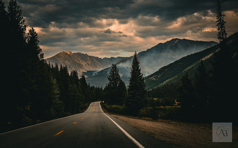 Camino oscuro entre montañas como símbolo de decisión, autonomía profesional y creencias limitantes